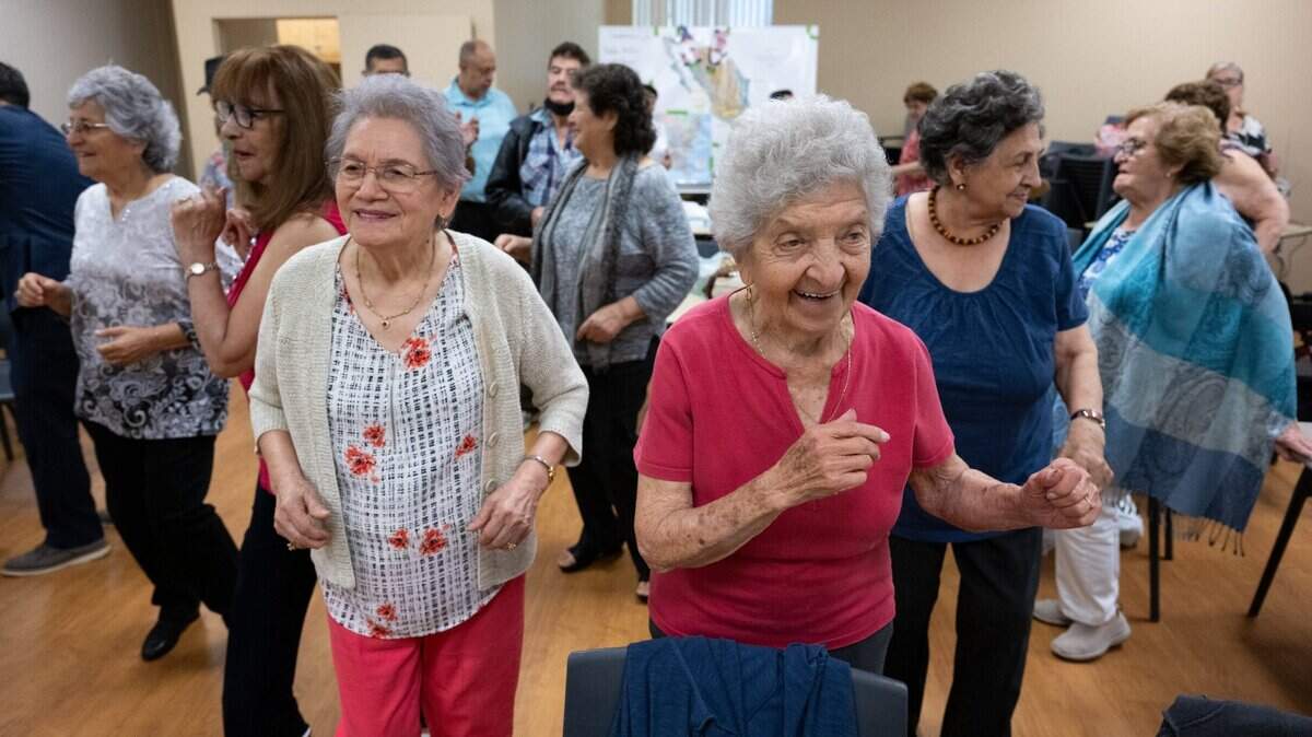 Yolanda Quevedo, 84, Josefina DaVila, 100, and Augustina Madrid, 86, sing an dance to music played by Liberato Correa during the weekly meeting for Manitos, a social group for older people who speak Spanish, at the Hart Senior Center on Wednesday, July 5, 2023, in Sacramento. The group meets weekly to do activities with the goal of preventing cognitive decline.