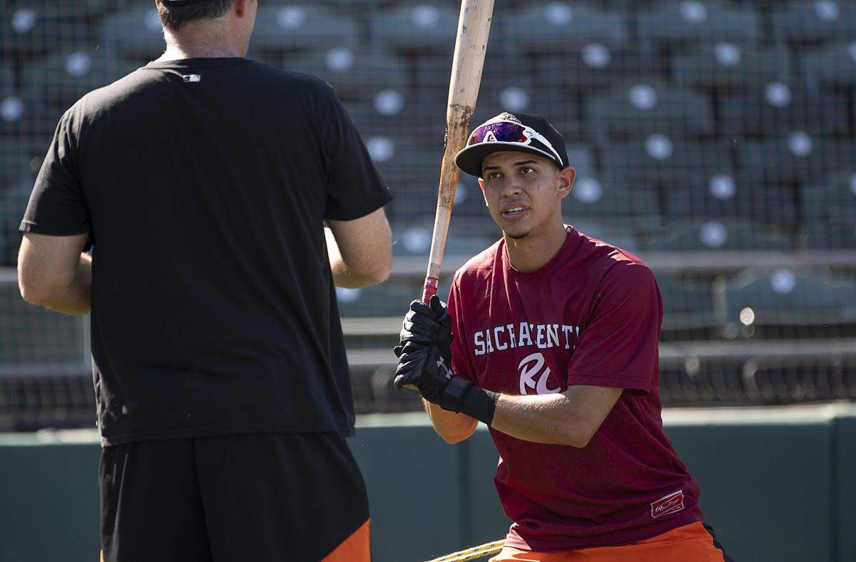 Infielder Mauricio Dubón, then of the Sacramento River Cats, talks with coach Damon Minor at Raley Field on Wednesday, Aug. 7, 2019 in West Sacramento. 