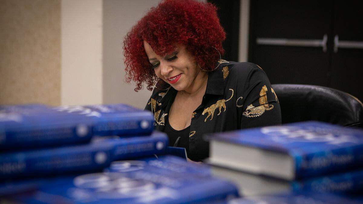 Pulitzer Prize-winning investigative journalist Nikole Hannah-Jones signs copies of her new book, “The 1619 Project: A New Origin Story,” before taking the stage at a book club event in Los Angeles in 2021.