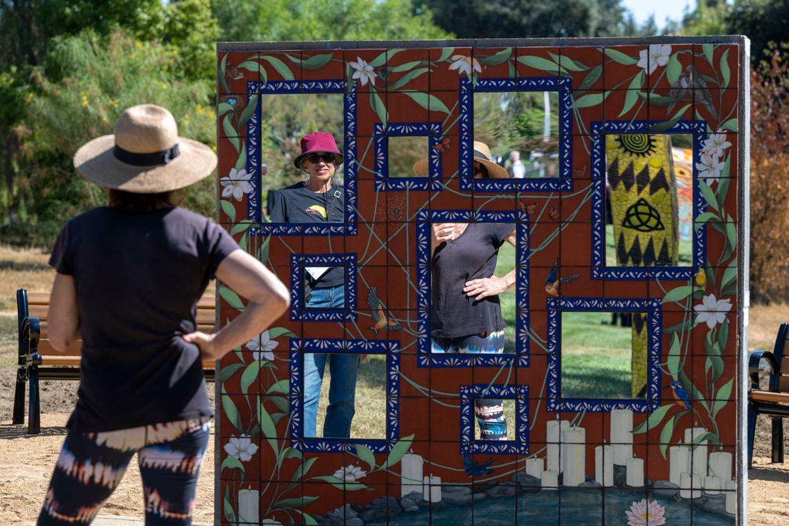 People look at the reflection wall at the COVID-19 Memorial unveiled at the Davis Cemetery District on Sunday.