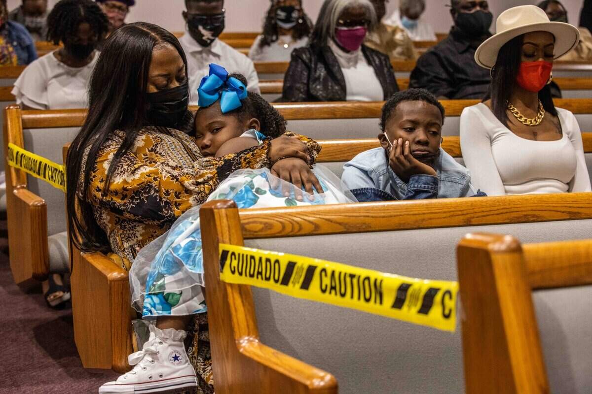 Kiana Riley-Matthews, left, holds her niece during the service.