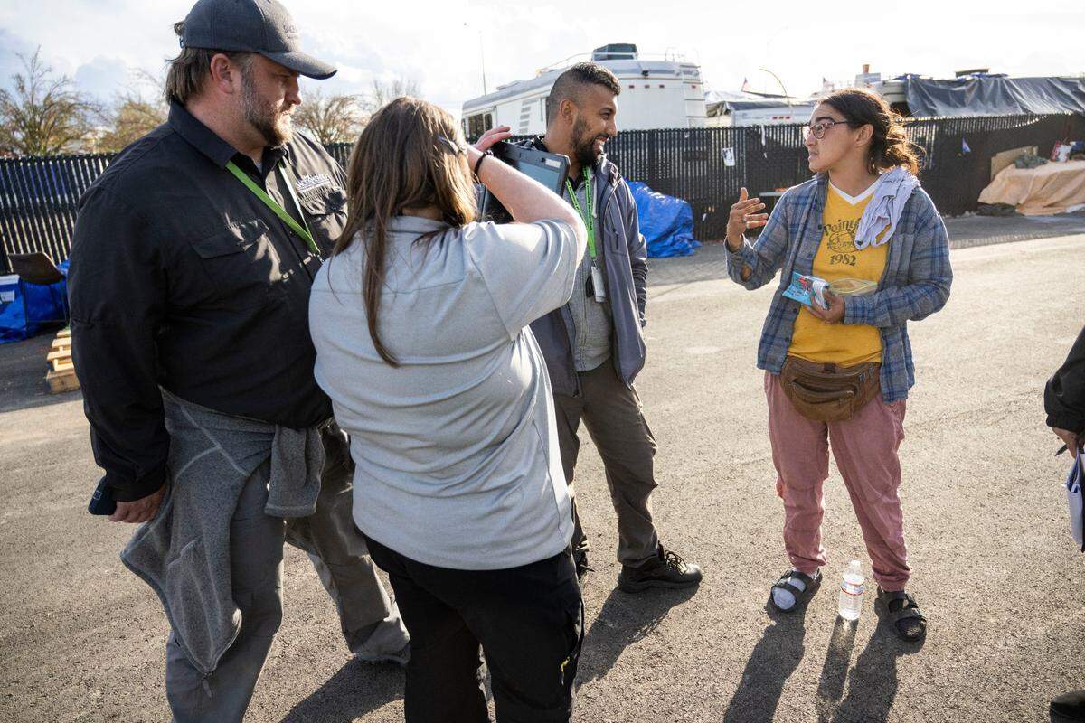 Homeless advocate Niki Jones, right, talks with Sacramento Department of Community Response staffers Hezekiah Allen, left, Hailey Weaslee and Jawid Sharifi at an encampment on Colfax Street in North Sacramento on Wednesday, Nov. 2, 2022. The camp is on city property that state officials have deemed too toxic for people to inhabit.
