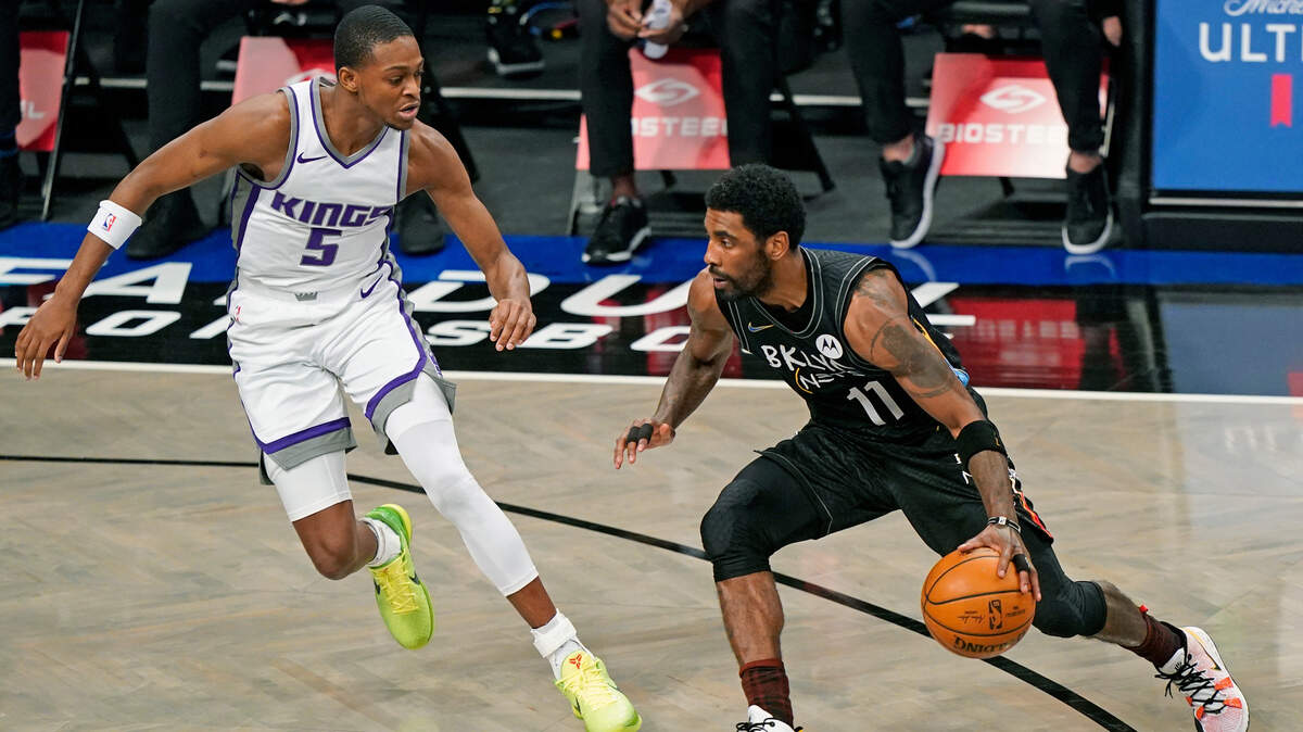 Brooklyn Nets guard Kyrie Irving (11) drives to the basket with Sacramento Kings guard De’Aaron Fox (5) defending during the first quarter of an NBA basketball game, Tuesday, Feb. 23, 2021, in New York. (AP Photo/Kathy Willens)