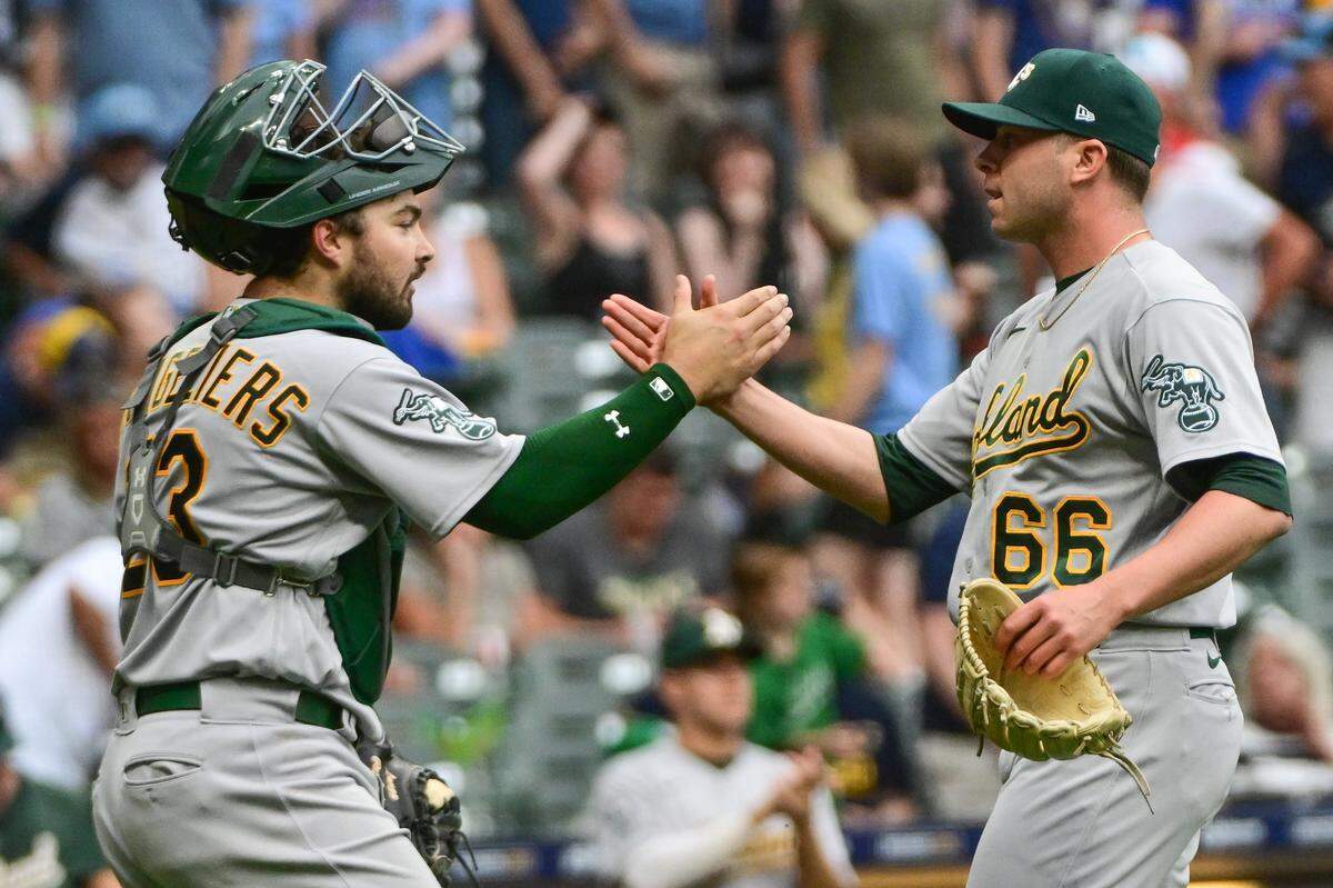 Then-Oakland Athletics pitcher Sam Long, right, and catcher Shea Langeliers celebrate after beating the Milwaukee Brewers on June 10, 2023, at American Family Field in Milwaukee.