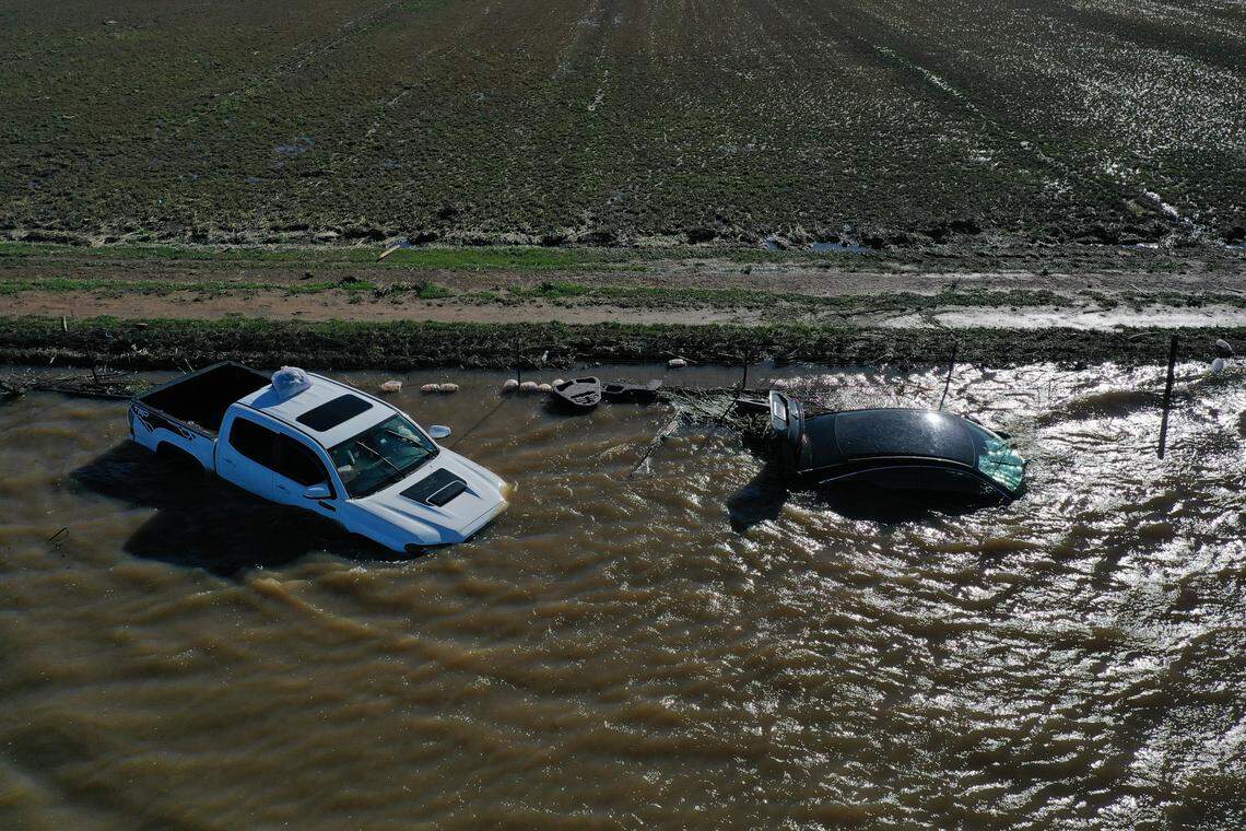 Vehicles are submerged in floodwaters on Twin Cities Road near where it crosses the Cosumnes River on Sunday after New Year’s Eve rains brought flooding to the Sacramento region.
