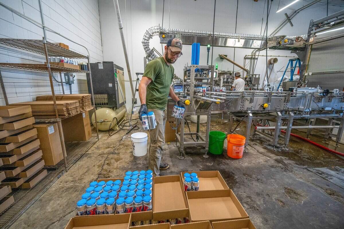 Co-owner Ian Marriott moves four-packs of rice lager off a conveyor belt at Balance Beerworks, a new brewery set to open in the former Device Brewing Co. space in Sacramento, on Monday, June 8, 2026.