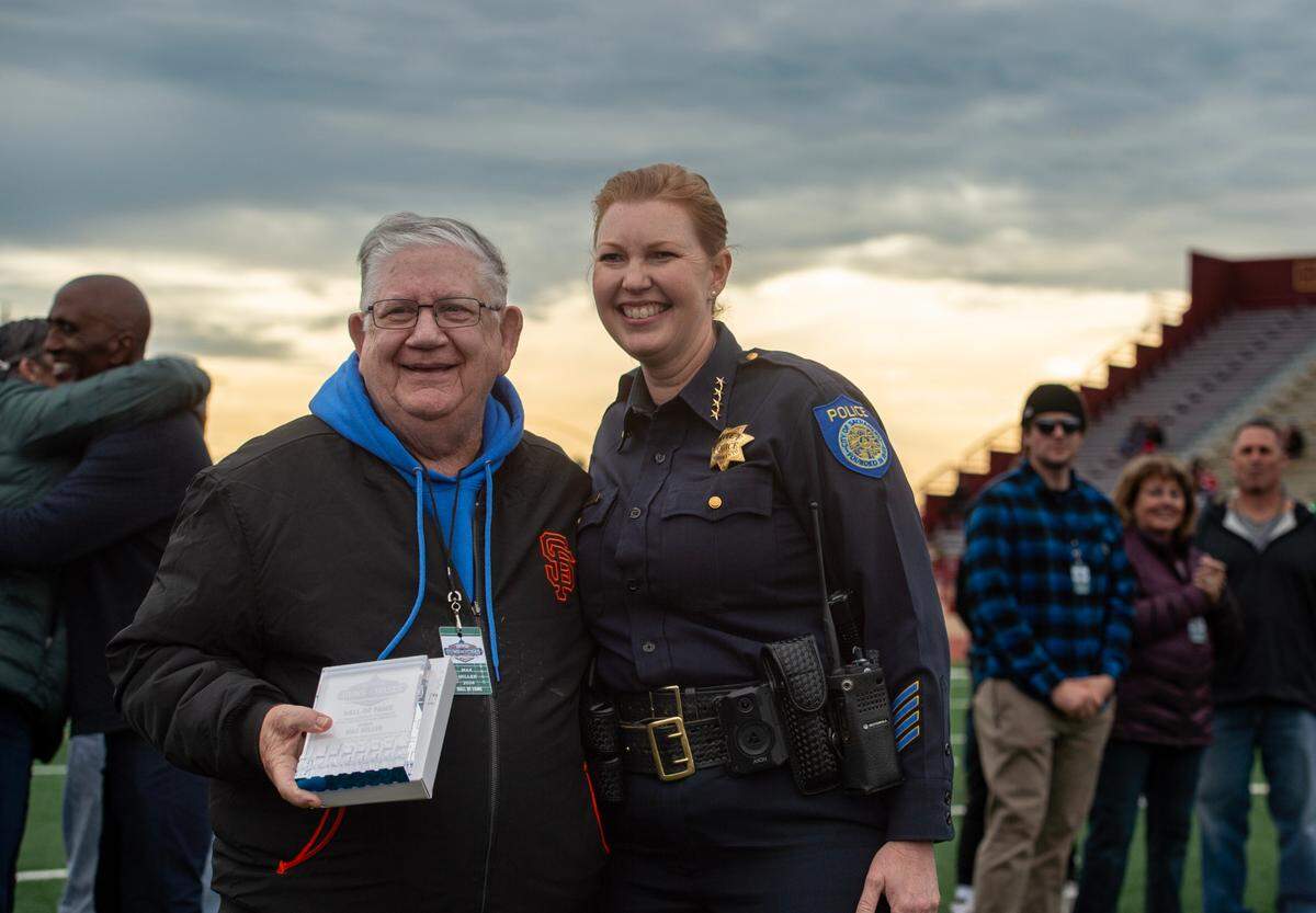 Sacramento high school football coaching legend Max Miller receives a Pig Bowl Hall of Fame plaque from Sacramento Police Chief Kathy Lester during halftime of the 50th Pig Bowl on Saturday.