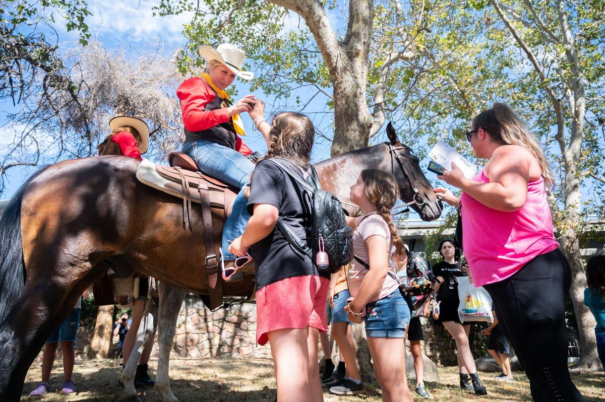Pony Express rider Steph Sassen, left, talks with children while they pet her horse, Roscoe, near the Pony Express Statue in Old Sacramento on Thursday. At about 1 a.m., Sassen adn Roscoe traveled a 2.7 mile stretch of the historic Pony Express trail.