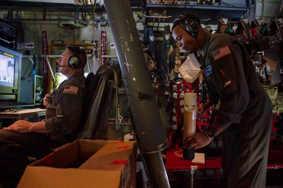 Chief Master Sgt. Jay Latham, left, a loadmaster for the “Hurricane Hunters,” works at his station while Tech. Sgt. Vince Boyd prepares to release a dropsonde from a WC-130J Super Hercules on Wednesday over the Pacific Ocean. The dropsonde collect data about wind speeds, temperatures, pressure and humidity of the storm before it reaches land.