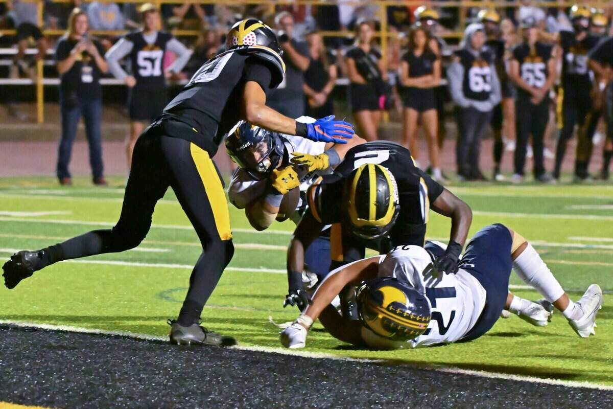 The Oak Ridge Trojans’ Erick Orme Jr. (24) dives past the Del Oro Golden defenders to score in the second half of the game on Friday in Loomis. Orme had 140 yards in addition to the touchdown.