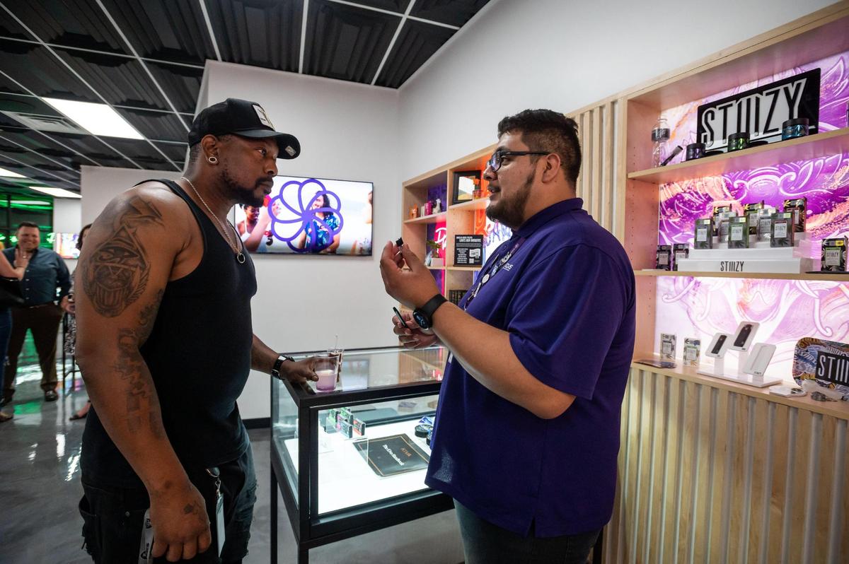 Kolas bud tender Ivan Rodriguez, right, talks about future products with Rodney Pope during a pre-opening party Wednesday for the Sacramento cannabis giant’s new retail store and resource center along the Arden shopping corridor in Sacramento. “A chill, laid-back and friendly vibe” is what Pope said attracted him to Kolas.