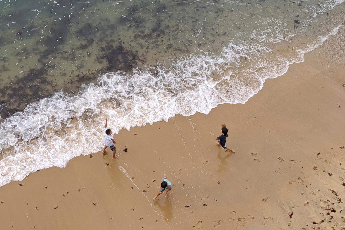 Children play on the beach in Monterey, Calif., Wednesday, July 1, 2020. Californians are being wooed by local tourism boards promising safe and clean lodging, dining and sightseeing in a bid to boost the state’s devastated economy. (AP Photo/Michael Liedtke)