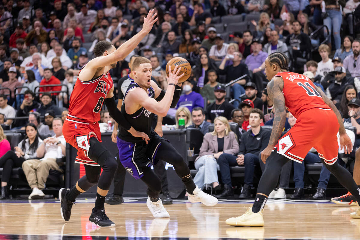 Sacramento Kings guard Donte DiVincenzo (0) drives to the basket between Chicago Bulls guard Zach LaVine (8) and forward DeMar DeRozan (11) during the fourth quarter on Monday, March 14, 2022. DiVincenzo had 15 points and seven rebounds.