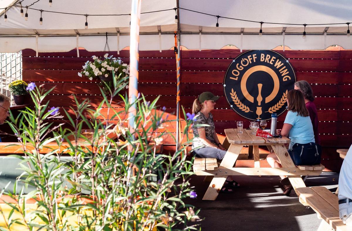 People drink under the covered area behind LogOff Brewing on Friday, Oct. 1, 2021, in Rancho Cordova.