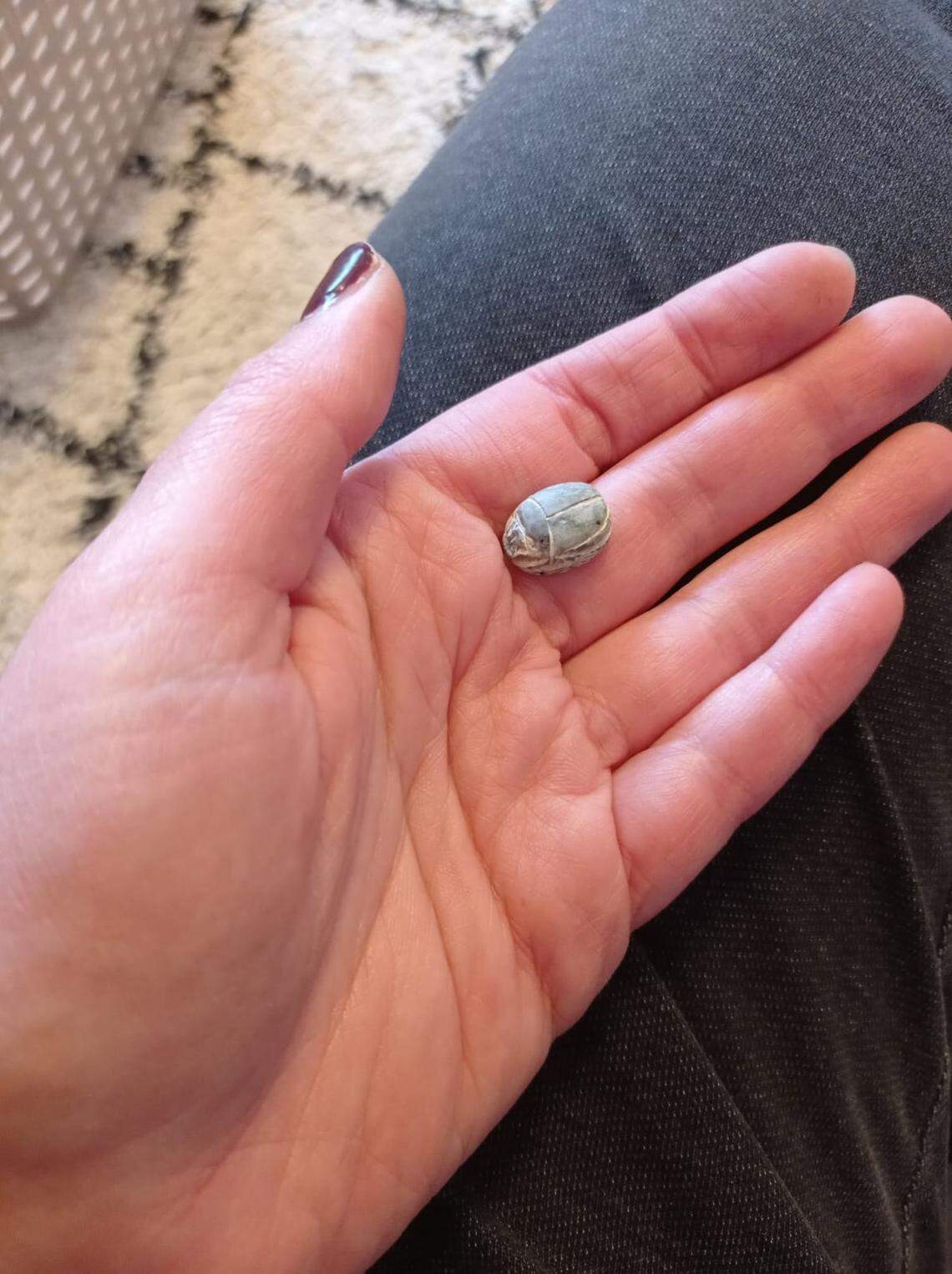 The scarab seal, as seen from the front, sits in someone’s hand.