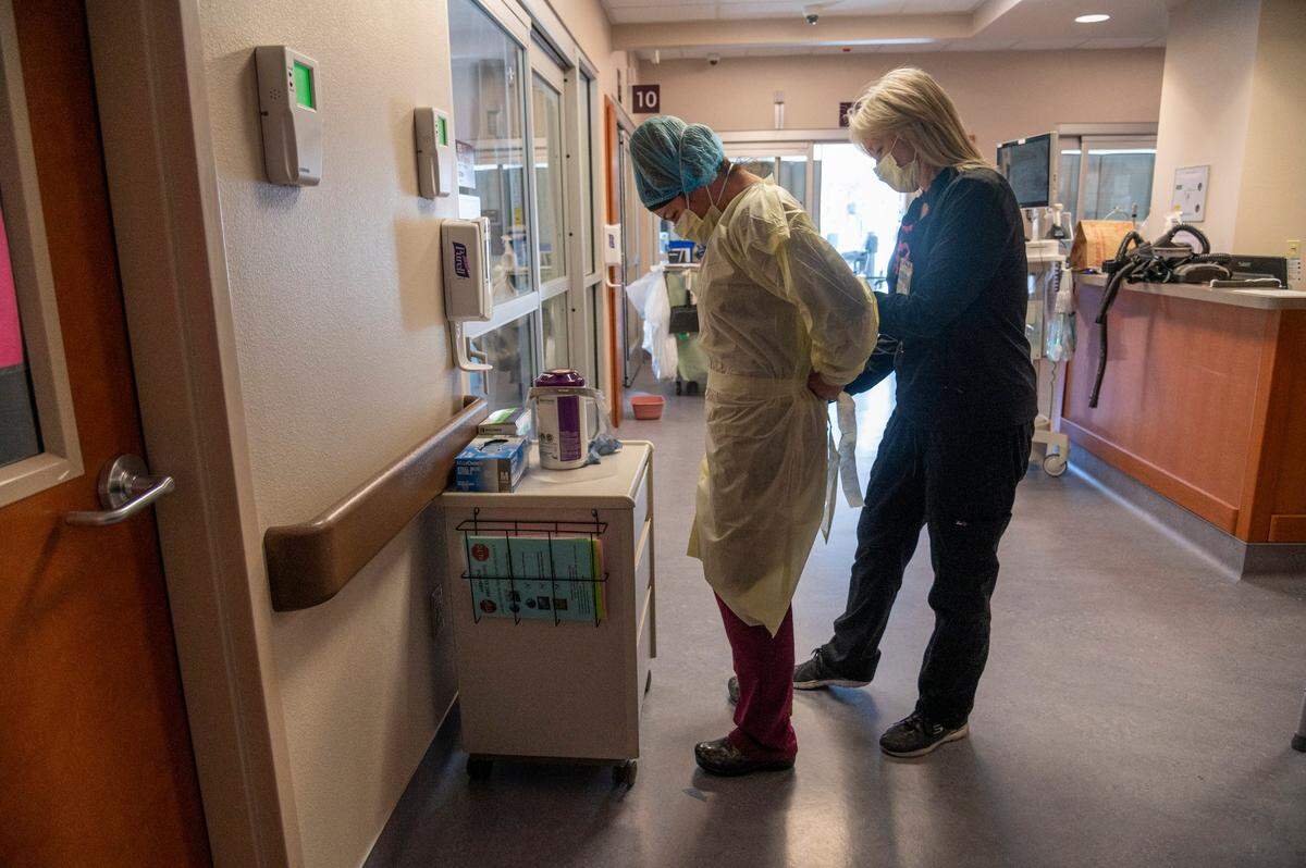 Registered nurse Alina Kendler, left, gets help securing her PPE from Kathy Durrett inside the ICU for COVID-19 patients at Marshall Medical Center’s hospital in Placerville on Wednesday, Dec. 2.