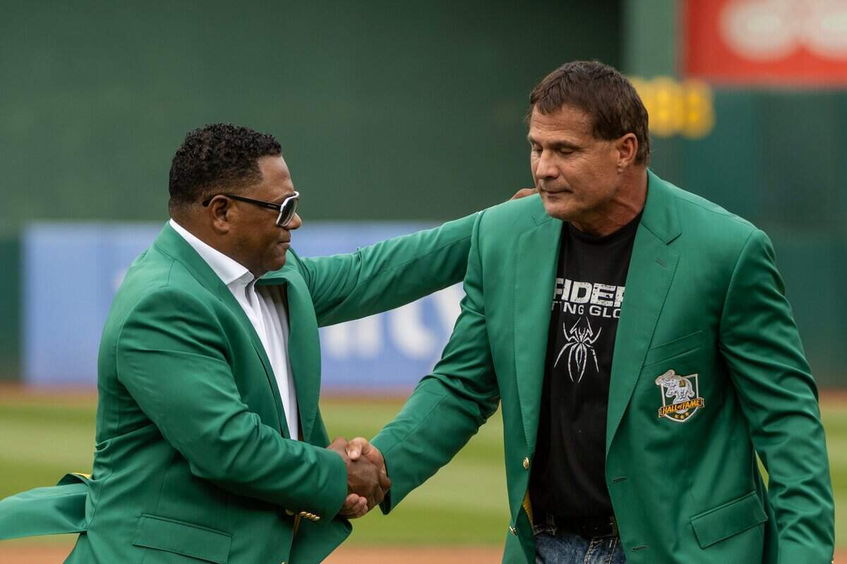 Miguel Tejada, left, congratulates José Canseco after the two were was inducted into the Oakland Athletics Hall of Fame on Aug. 17 at the Oakland Coliseum.