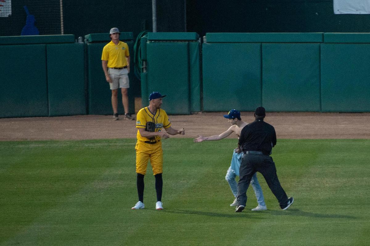 A fan runs to center field to get an autograph from former Giants outfielder Hunter Pence during the Savannah Bananas World Tour on Saturday, July 29, 2023, at Sutter Health Park in West Sacramento.