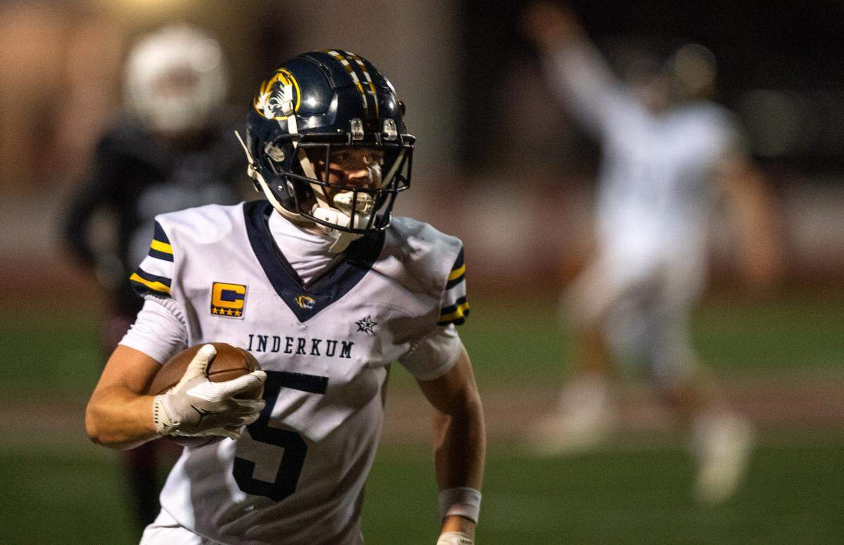 The Inderkum Tigers’ Jordan Cole (5) takes a short fourth-down pass 35 yards for a touchdown in the fourth quarter against the Woodcreek Timberwolves on Friday in Roseville. 