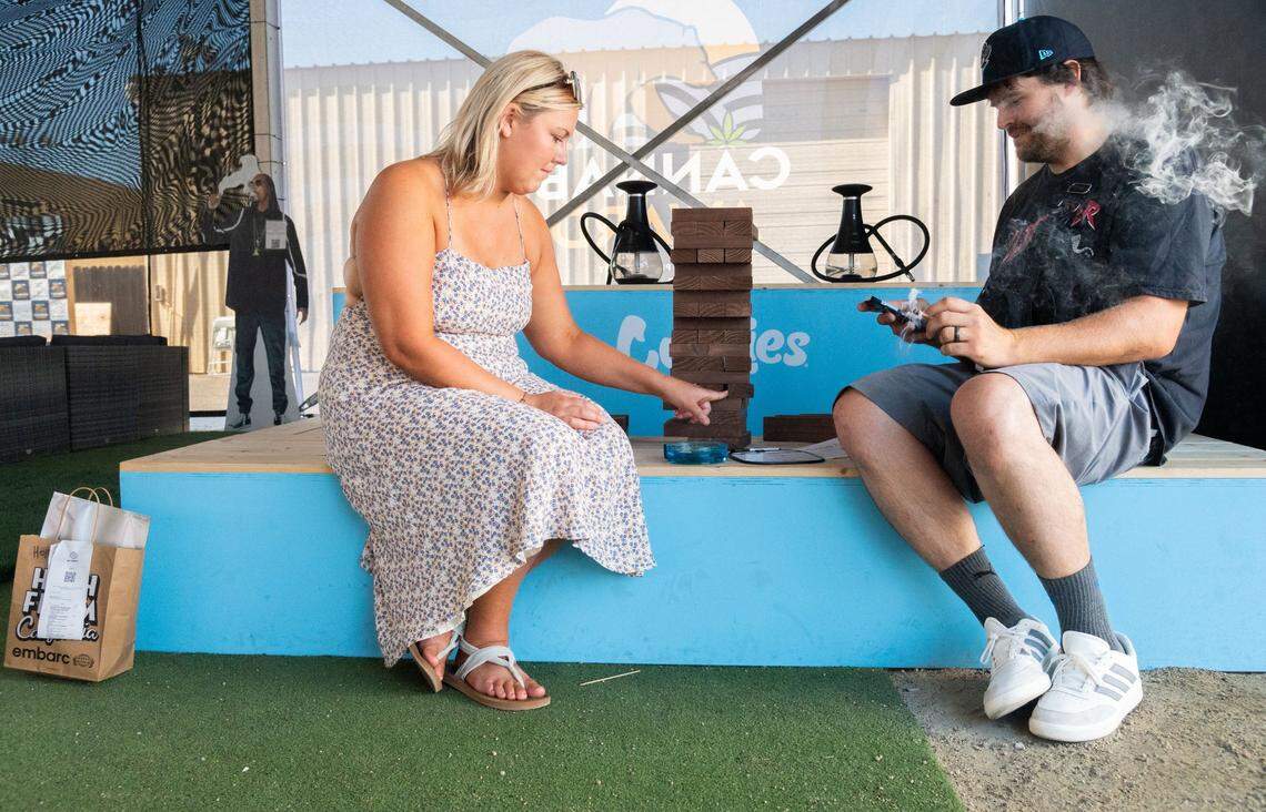 Chelsey Anderson, left, plays Jenga with her husband, Oliver Cripe, while the pair share a joint in the cannabis consumption lounge on Tuesday during the California State Fair in Sacramento. “There was lots of room for people to enjoy themselves, and the environment was well done,” Cripe said. “Chelsey and I love games of all types.”