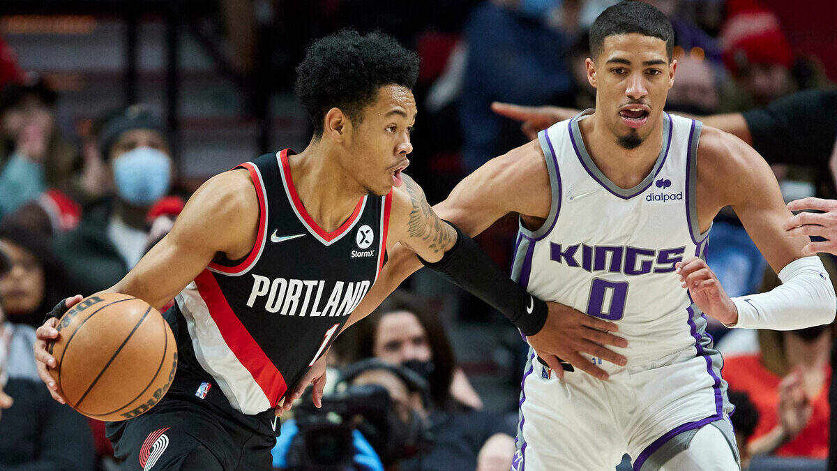 Portland Trail Blazers guard Anfernee Simons, left, dribbles around Sacramento Kings guard Tyrese Haliburton during the first half of an NBA basketball game in Portland, Ore., Sunday, Jan. 9, 2022. (AP Photo/Craig Mitchelldyer)