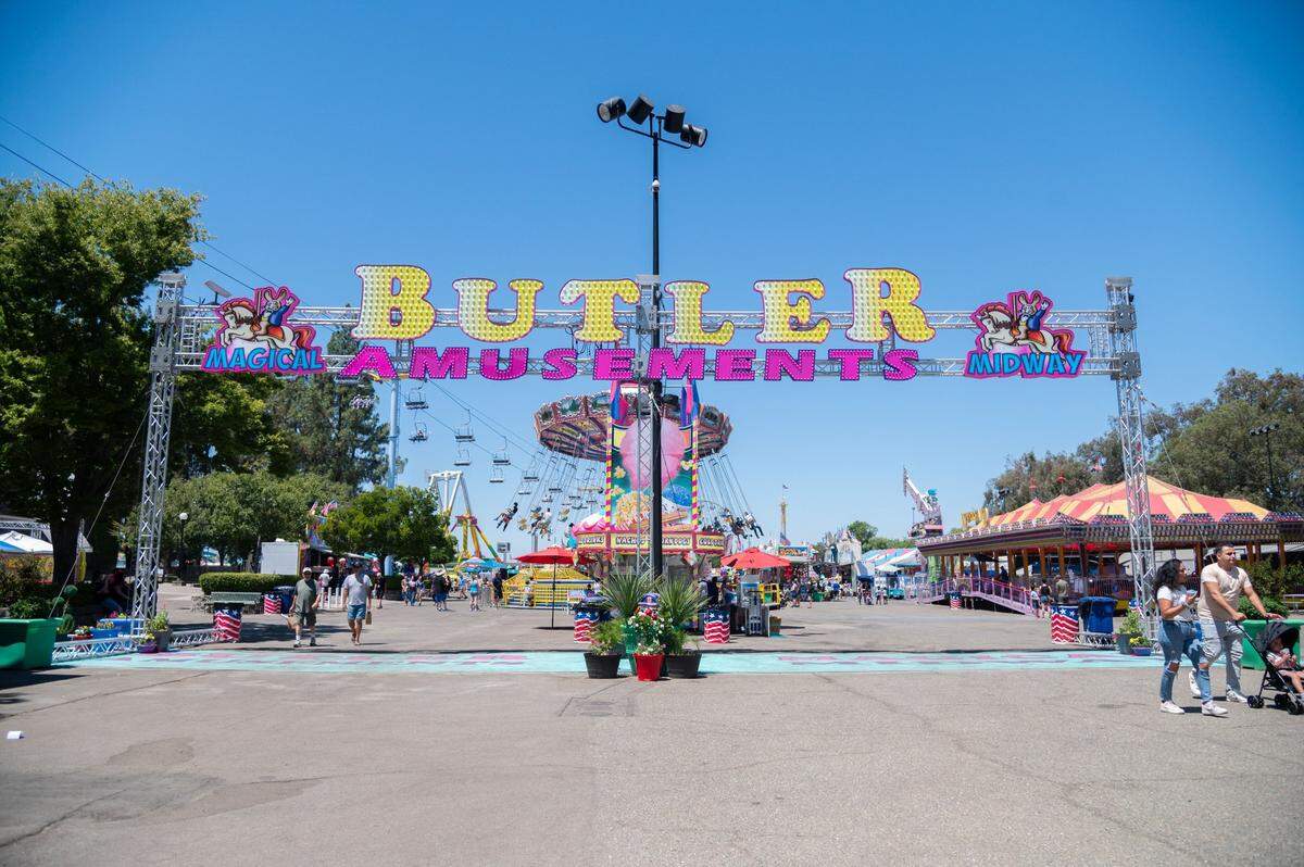 Visitors walk past the Butler Amusements sign at the California State Fair on Tuesday. The fair started on July 12 and will last through July 28.