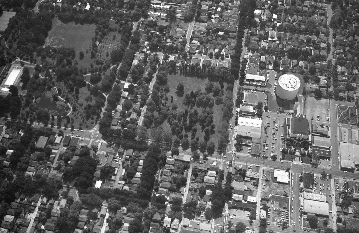 A 1953 aerial image shows Alhambra Boulevard before the construction of a middle school at the site of the former New Helvetia Cemetery, center. The Alhambra Theatre, demolished in 1973, stands at right near the East Sacramento city water tank. At left are McKinley Park’s duck pond and rose garden.