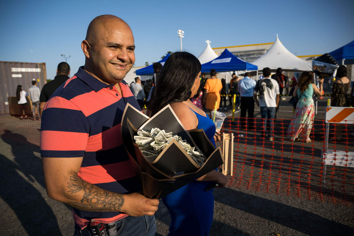 Gustavo Esquivel walks towards the stadium entrance before the graduation ceremony at Grant Union High School on Thursday, June 1, 2023, in Sacramento’s Del Paso Heights neighborhood. He carries graduation money for his son, also Gustavo Esquivel.