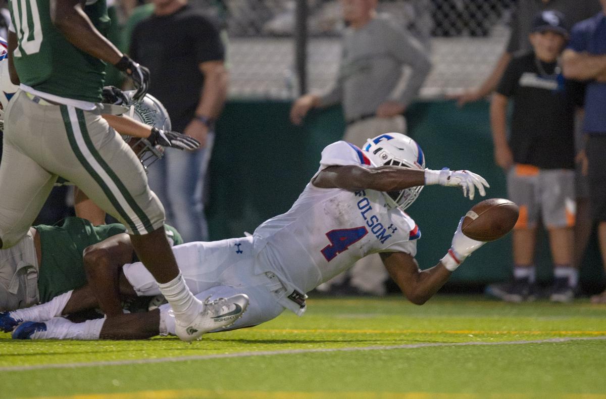 Folsom Bulldogs’ Daniyel Ngata loses the ball as he crosses the goal line in the second quarter against De La Salle on Friday in Concord.