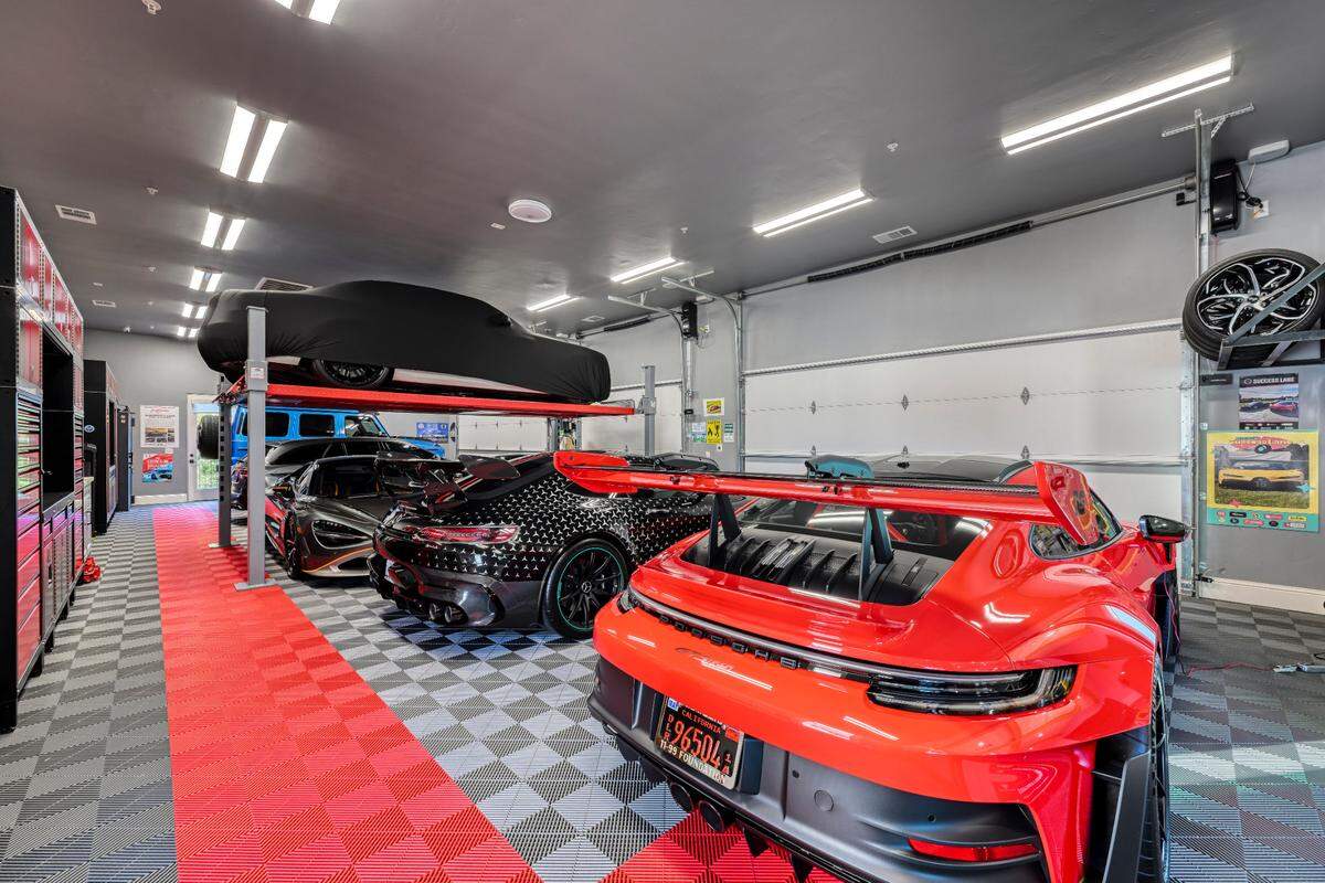 About 10 super exotic sports cars are parked in the custom garages with Swisstrax flooring.
