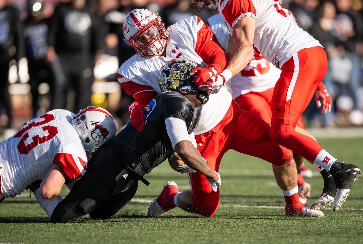 Running back Jarred Houston, with the Sacramento region law enforcement Hogs, is brought down hard by Thadon Haley, center, with the statewide fire service Fire Dogs, with assistance from Corey Crowder, left, and Colin Kelly during the 49th Pig Bowl on Saturday. Haley was named defensive player of the game.