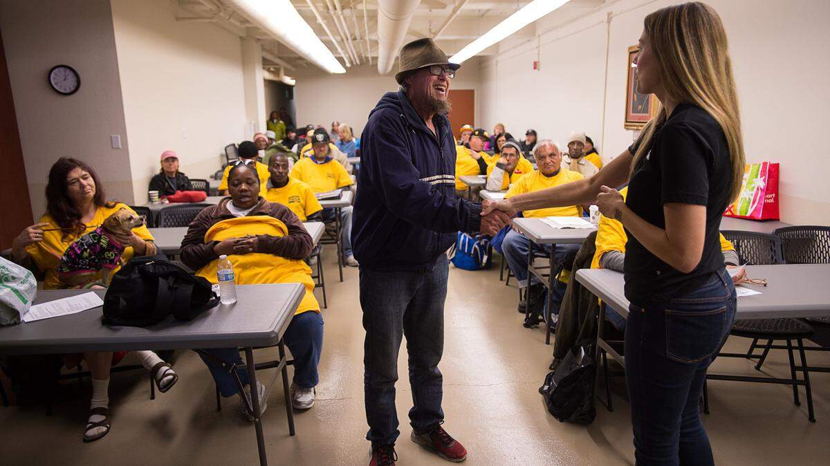 Dan Hoagland is congratulated by Sacramento Downtown Streets Team project manager Rachel Davidson on Wednesday as he is inducted in the program. The Sacramento's Downtown Streets Team are homeless people who clean up hotspot areas around the city in exchange for weekly stipends of gift cards to Target and other places. The city hired the Bay Area-based organization to mitigate effects of the Winter Triage Shelter in North Sacramento.