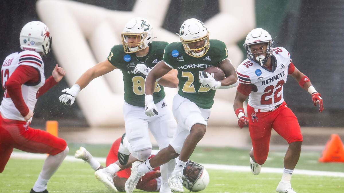 The Sacramento State Hornets’ Elijah Tau-Tolliver (25) runs back a kickoff as Richmond Spiders defensive back Trae Tomlinson (22) pursues at right during the first half of an NCAA FCS college football playoff game Saturday, Dec. 3, 2022, at Hornet Stadium in Sacramento. Tau-Tolliver later returned the second-half kickoff for a touchdown.