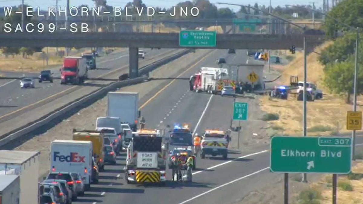 Emergency crews tend to a traffic crash between a big rig and a sedan on southbound Highway 99 at Elkhorn Boulevard on Thursday, July 24, 2025.