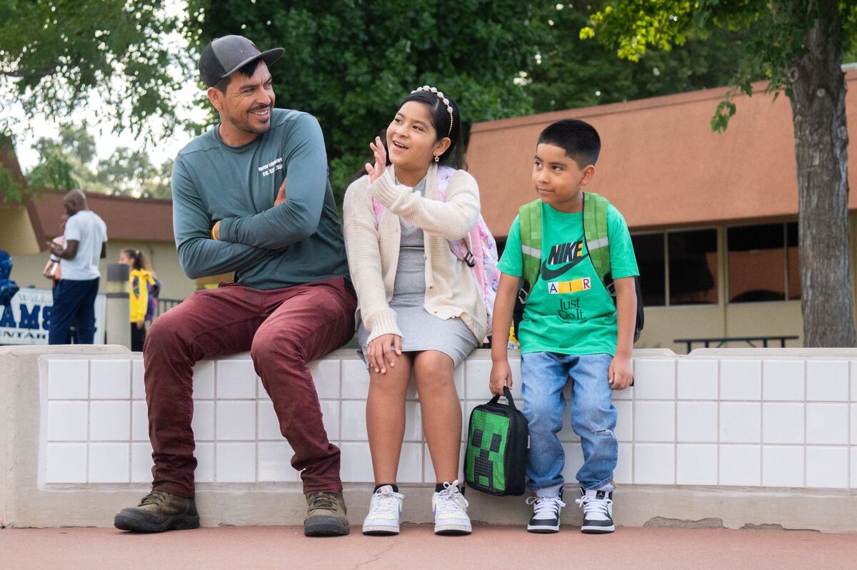 Raul, Julissa and Matthew Mendoza sit in front of Williamson Elementary School in Rancho Cordova before classes start on Thursday. Fifth-grader Julissa Mendoza said going to school with her first-grade brother, Matthew, means “being really overprotective of him and taking care of him, making sure he’s OK.”