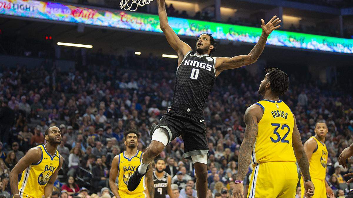 Sacramento Kings forward Trevor Ariza (0) dunks the ball between Golden State Warriors guard Alec Burks (8), and Golden State Warriors forward Marquese Chriss (32) during a game at the Golden 1 Center on Monday, Jan 6, 2020 in Sacramento.