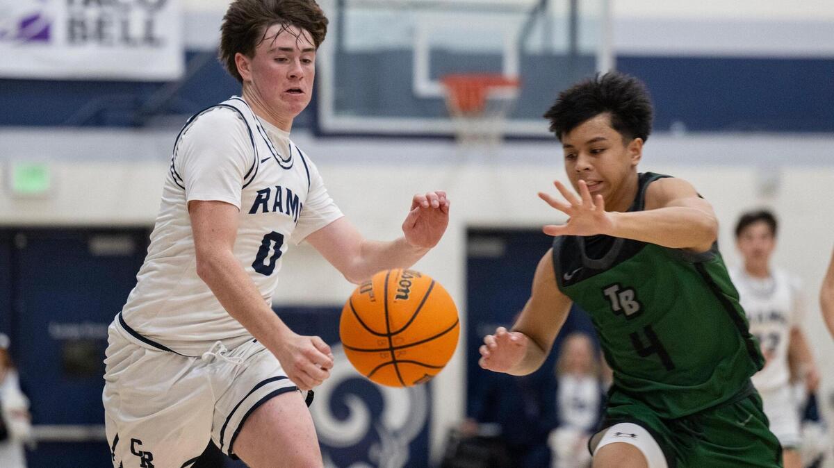 The Casa Roble Rams’ Ace Villegas (0) and the Twelve Bridges Raging Rhinos’ Derek Baltazar (4) chase down a loose ball in the first half of a CIF Northern California Division IV boys basketball playoff game Tuesday in Orangevale.