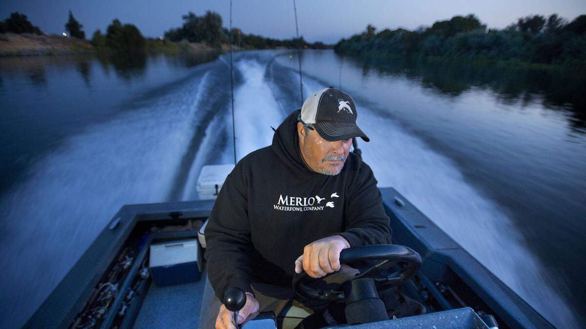 Fishing Guide Jeff Gonzales pilots a boat down the Sacramento River to take clients on a salmon fishing trip near Los Molinos before sunrise in September 2015.  Salmon fishing seasons on rivers such as the Sacramento may be curtailed in the coming months due to low numbers of fish.