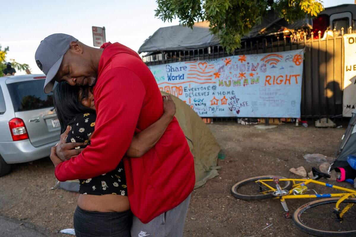 Pastor Deshon Brown of IM Ministries hugs a Camp Resolution resident outside the encampment as the city of Sacramento arrived to remove the homeless encampment on Monday.