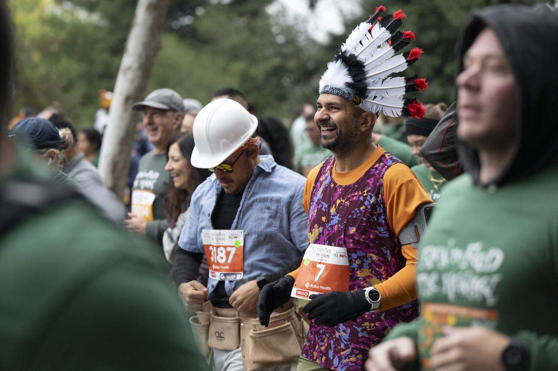 Ryan Hatcher, left, and Vic Sandhu, right, run dressed as The Village People during the Run to Feed the Hungry in Sacramento on Thursday, Nov. 27, 2025.