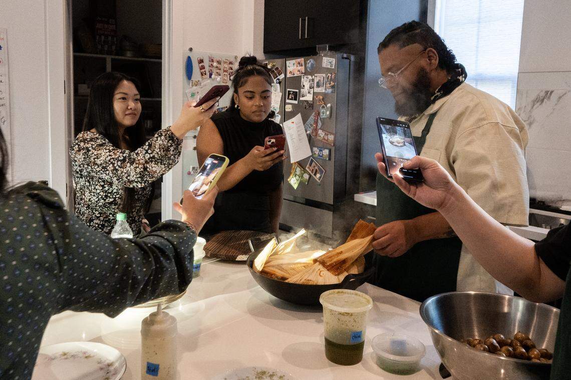 Annie Ngo, Chloe Davis and other guests take photographs of the mole created by Chef Eríc Martínez of the Crispín Supper Club on Friday, April 24, 2026, in Sacramento.