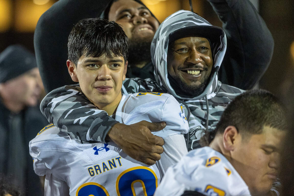Grant kicker Jose Romero is is hugged by assistant coach Corey Brown after making the winning field goal in a 32-30 victory over St. Francis CIF Northern California Division 2-AA championship game on Friday in Mountain View.