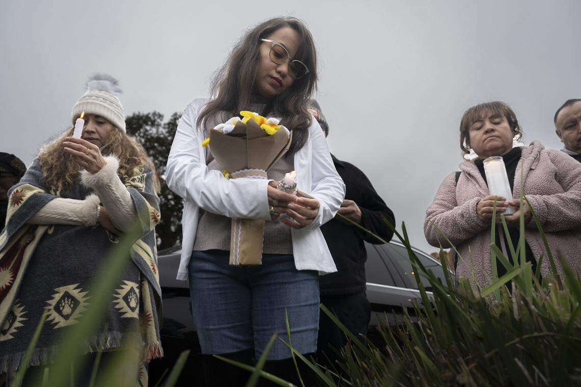 Beatriz Vega, Ellein White and Luz Guzman stand in prayer as they take part in a vigil on Sunday for the four people killed and 11 injured after a mass shooting near Stockton the night before.