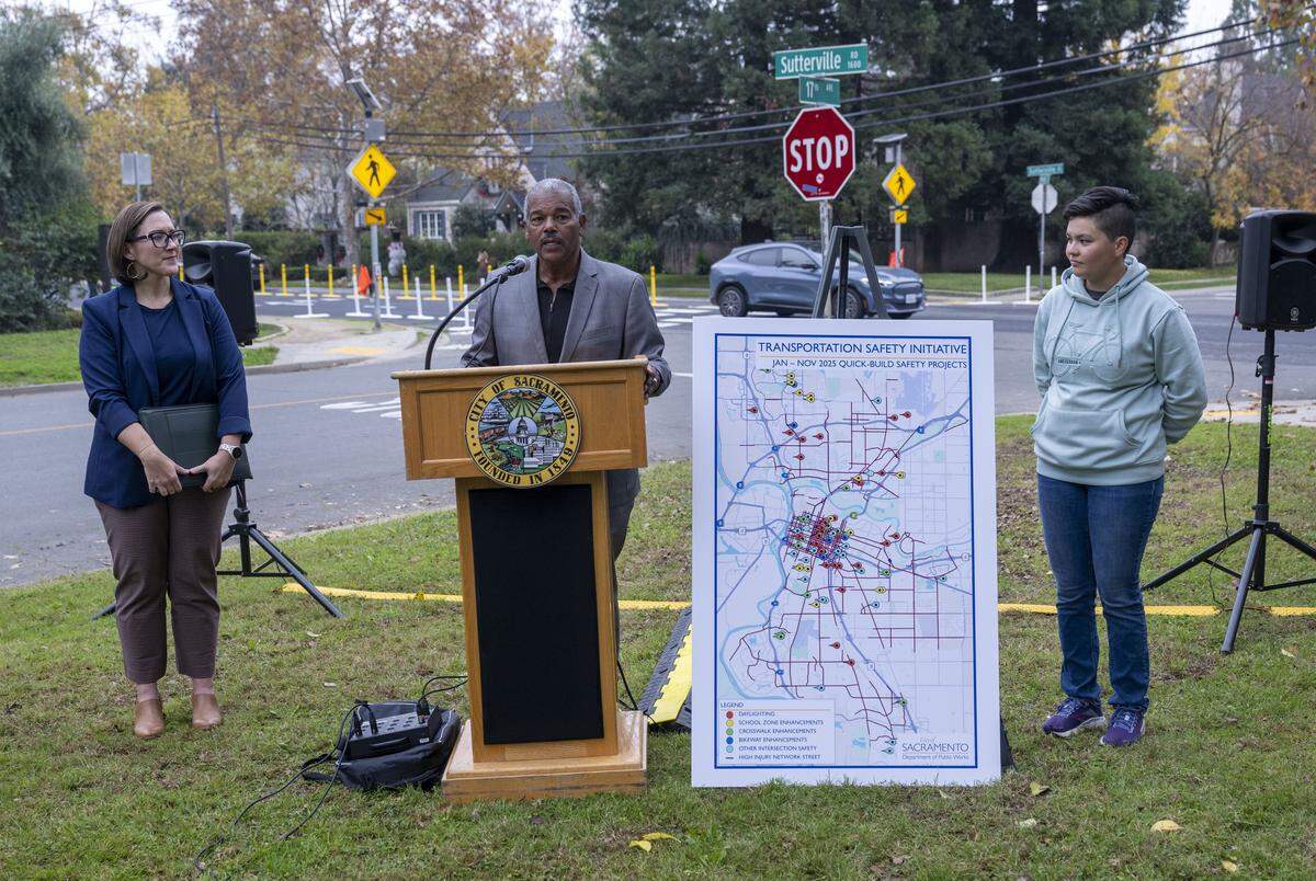 Sacramento City Councilmember Rick Jennings speaks about transportation safety improvements on Wednesday near the location where Alena Wong, right, was hit by a motorist as she crossed the street on Sutterville Road and Mead Avenue. 