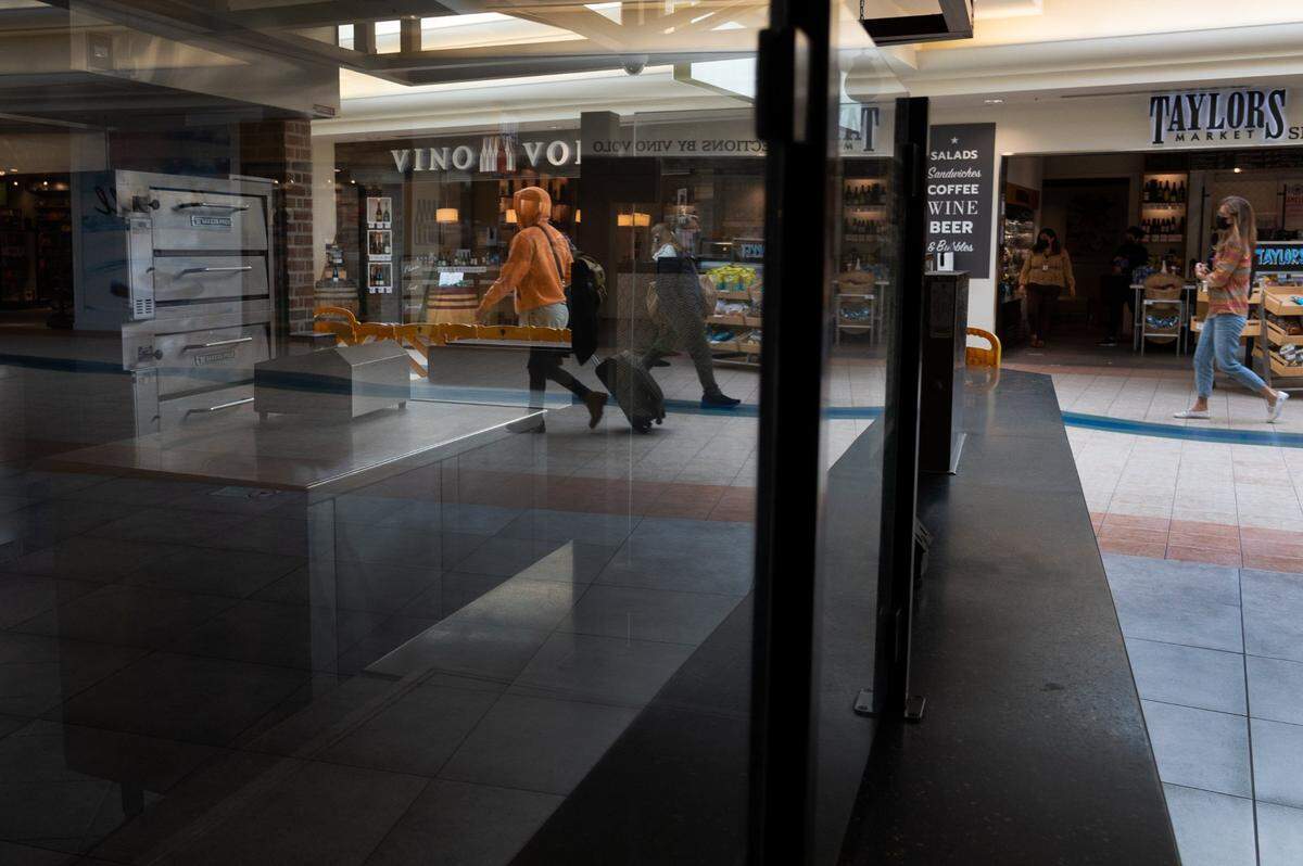 Passengers walk past the permanently closed Paseanos restaurant in Terminal A at the Sacramento International Airport on Tuesday, Oct. 26, 2021.