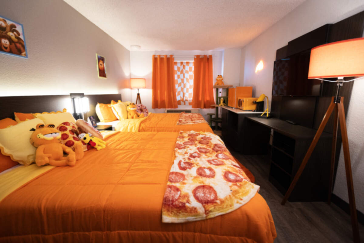 A Garfield-themed motel room at Motel 6 features organized bedding, Garfield stuffed animals, and pizza throw blankets. Rooms are available in 2024 at Motel 6 at 3796 Northgate Blvd. in South Natomas.