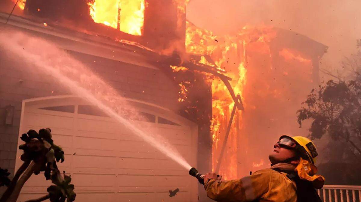 Firefighters battle a house fire off Bollinger Drive in Pacific Palisades on Tuesday, Jan. 7, 2025. (Wally Skalij/Los Angeles Times/TNS)