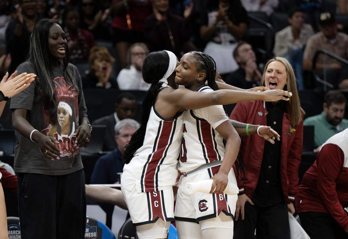 South Carolina Gamecocks guard Ta'niya Latson (00) is embraced by Raven Johnson (25) in the second half against the Oklahoma Sooners during an NCAA Women’s Basketball Tournament Sweet 16 game Saturday at Golden 1 Center in Sacramento.
