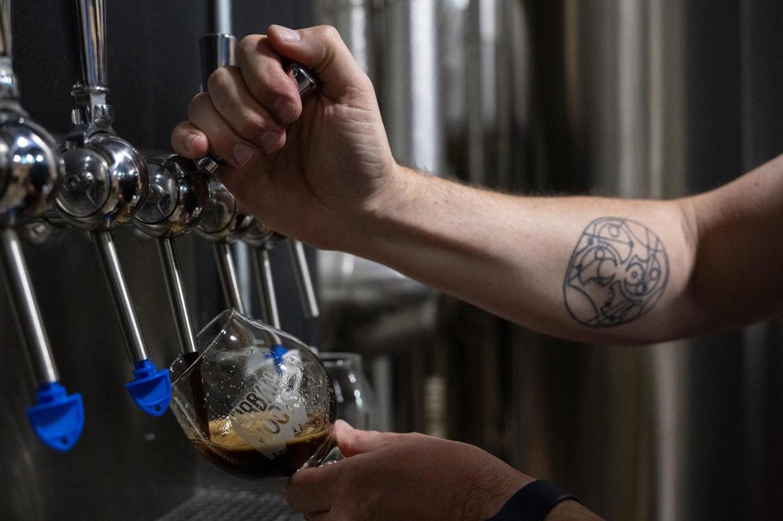 Urban Roots brewer Peter Hoey pours a stout beer made at his Sacramento brewery on Monday, April 14, 2025.
