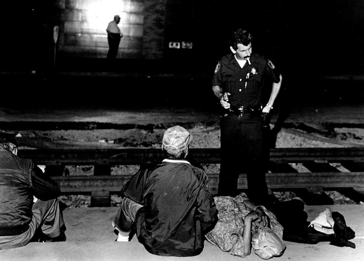 Officer Bill Lyons strikes up a conversation with Sacramento homeless residents on K Street Mall, where the installation of light rail tracks was in progress, in September 1986. Lyons, once dubbed the “Sidewalk Saint to winos,” was known to carry a pack of Marlboro cigarettes to hand out to defuse tense encounters.